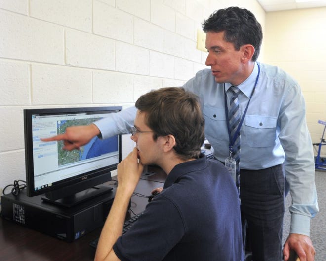 Burlington County Institute of Technology science teacher Peter Dorofy works with student Sean Murray during a GeoSpacial Tech Class.