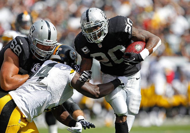 Oakland Raiders running back Darren McFadden, right, carries the ball past Pittsburgh Steelers linebacker Lawrence Timmons as Raiders tackle Jared Veldheer, blocks during the second quarter of an NFL football game in Oakland, Calif., Sunday, September 23, 2012.