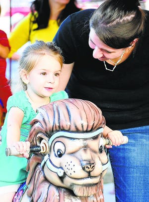 Jennifer Gibbons, right, rides the carousel with her daughter Kaelyn Gibbons at the Madison County Fair in Comer, Ga., Wed., Sept. 26, 2012.