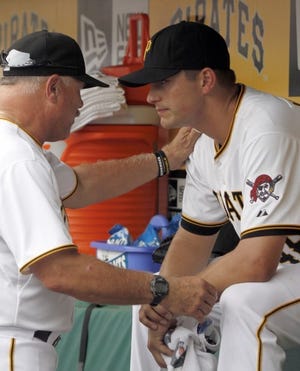 Pirates pitching coach Ray Searage, left, talks with relief pitcher Jared Hughes in the dugout after Hughes was taken out after giving up two runs in the seventh inning of a game against Arizona in August.