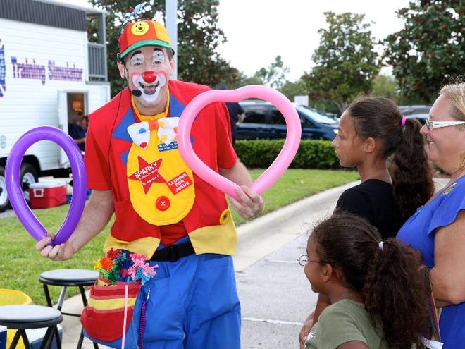 Christopher Paone aka Sparky the Clown, creates some balloon art for kids who attended Florida Hospital Flagler's 10th anniversary celebration.
