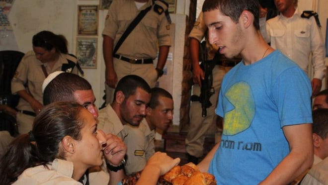 Yoel Lipszyc serves refreshments to members of the IDF at the Thank a Soldier organization. Photo courtesy of Rabbi Didy Waks