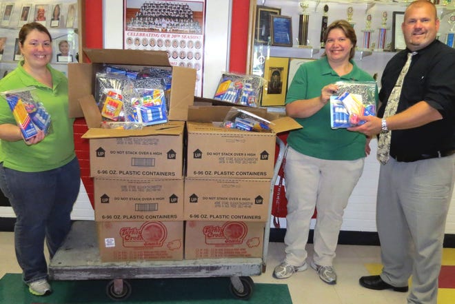 Ruth Valdivez, left, and Dollar Tree Manager Kathy Williams, center, join in the front lobby of Delaware Valley Elementary School with Principal Aaron Weston, who gladly accepted the generous community-collected gift.