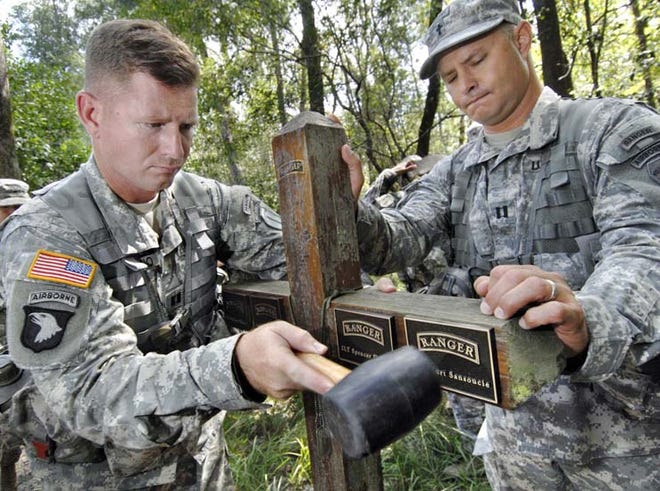 Army Rangers add a plaque to a memorial Wednesday on the Yellow River that marks where 4 Ranger students died in 1995 due to inclement weather and flooding during a training exercise.