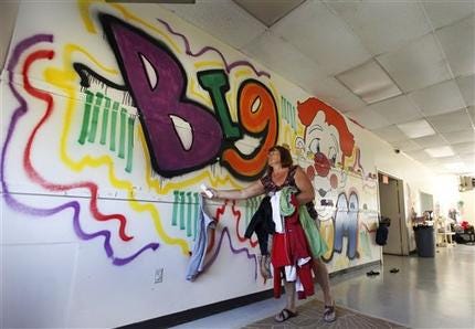 Tappahannock Children's Center administrator Ina Minter removes coats from in front of a mural painted by rapper Chris Brown as part of his community service at the center in Tappahannock, Va.