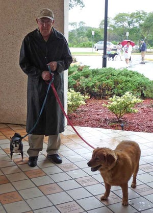 In a photo from a previous pet blessing at St. Anastasia, John Geiger gets a double blessing, arriving with his bird and dog. Contributed photo.