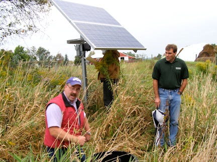 Jerusalem farmer John Kriese, assisted by Tom Eskildsen of Yates County Soil & Water Conservation District, describes the solar-powered watering system which provides enough water for 50 head of cattle.