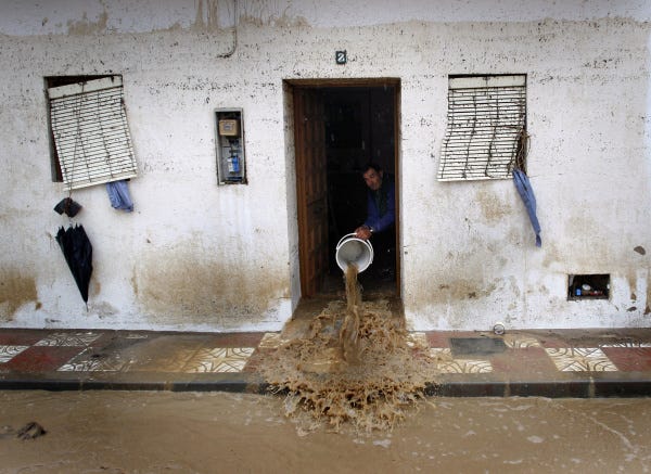 A man clears muddy water from his house after storms in southern Spain triggered flash flooding in the town of Villanueva del Rosario. Seven people were killed yesterday, and hundreds of people evacuated in the regions of Andalucia and Murcia. Roads were closed, and public transport was disrupted. Four of the victims were in the tourist destinations of Malaga and Almeria on the coast.