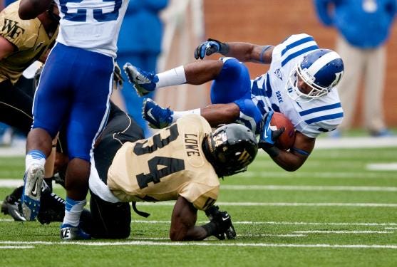 Duke's Desmond Scott is tripped up by Wake Forest's Duran Lowe (34) during the first half of an NCAA college football game in Winston-Salem, N.C., Saturday, Sept. 29, 2012. (AP Photo/Winston-Salem Journal, Lauren Carroll)