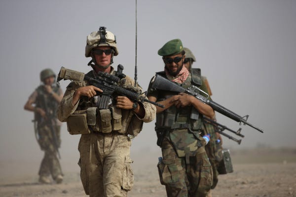 Marine Sgt. Matthew Duquette, left, of Warrenville, Ill., walks with Afghan army Lt. Hussein during a joint patrol in Helmand province in southern Afghanistan.