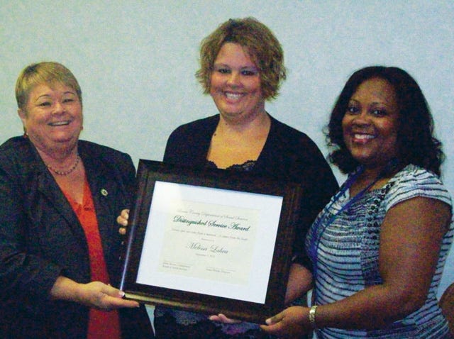 Linda Sutton, left, and Valerie Williams, right, present Melissa Labra the Lenoir County Department of Social Services Distinguished Service Award for the fourth quarter of 2012.
