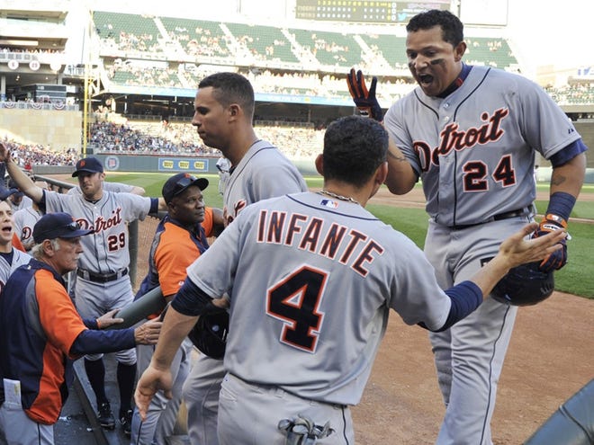 Detroit Tigers' Miguel Cabrera, right, is congratulated in the dugout after his three-run home run off Minnesota Twins' Casey Fien in the eighth inning of a baseball game Saturday, Sept. 29, 2012, in Minneapolis.
