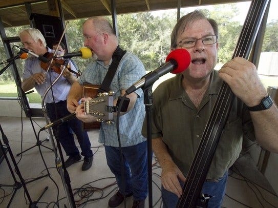 Rick Hinson, right, bassist and tenor singer with the Southern Express Bluegrass Band, along with Donnie Harvey, left, Steve Durrwachter, center left, Larry Jackson, Jr., center right, and Bryce Hall (not shown) entertain the crowd during Swamp Fest at Colt Creek State Park Saturday. The nature filled day of fun featured guided tram tours, guided trail hikes, bluegrass music, barbecue lunch, a kid's fishing derby, and land management agency educational booths.