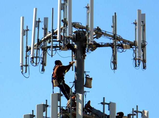 A man works on a cell tower in this News Herald file photo