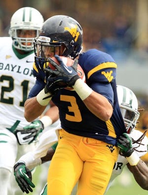 West Virginia receiver Stedman Bailey (3) catches a pass and is tackled by Baylor's K.J. Morton (8) as Josh Wilson (21) looks on during their NCAA college football game in Morgantown, W.Va., Saturday, Sept. 29, 2012. (AP Photo/Christopher Jackson)
