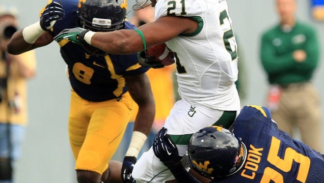 West Virginia defenders Darwin Cook (25) and Karl Joseph (8) try to bring down Baylor’s Jarred Salubi (21). The Mountaineers struggled all day to tackle Baylor players.