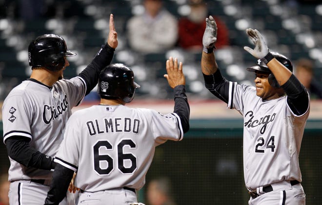 Chicago White Sox's Dayan Viciedo, right, is congratulated by A.J. Pierzynski, left, and Ray Olmedo after Viciedo hit a grand slam in the ninth inning of a baseball game, Monday, Oct. 1, 2012, in Cleveland. Pierzynski, Olmedo and Jordan Danks scored. The White Sox won 11-0.