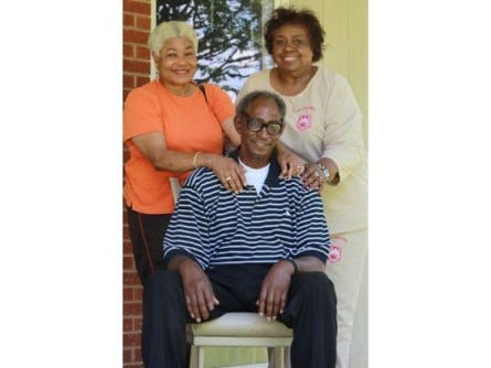 File photo from May 2012, Willie Grimes is flanked (L-R) by his sister Gladys Perkinns and his cousin, Martha Harrison on the front porch of a home on Bessemer City Road.
