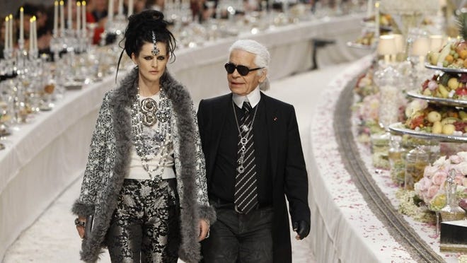 German fashion designer Karl Lagerfeld with at his side British model Stella Tennant, left, acknowledges applause at the end of the presentation of his Paris-Bombay collection for Chanel, presented at the Grand Palais in Paris on Tuesday.