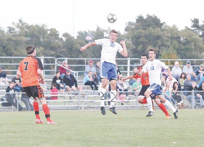 Ionia senior Corbin Kuhns heads the ball into the air Tuesday night during the Bulldogs' Capital Area Activities Conference Cup.