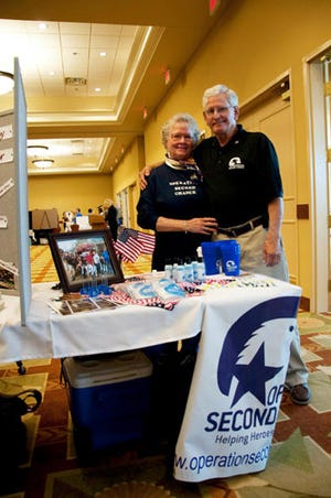 Molly and Bob Larson, representatives of an organization that supports veterans, pose at their booth during the Combined Federal Campaign kickoff at the Soundside Club at Hurlburt Field, Fla., Sept. 25, 2012. Many booths provided complementary items to market their respective programs within the CFC.