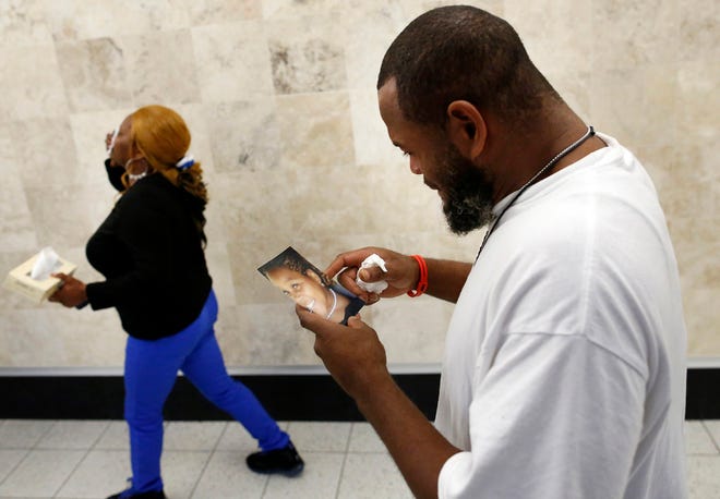 Jearick Mack sobs over a photo of his slain daughter Jearicka Mack, 15, as he and Jearicka's mother Trenesha Thomas, 36, leave the Alachua County Criminal Courthouse following a first degree murder conviction of Jearicka's killer Dontavious Copeland on Friday.