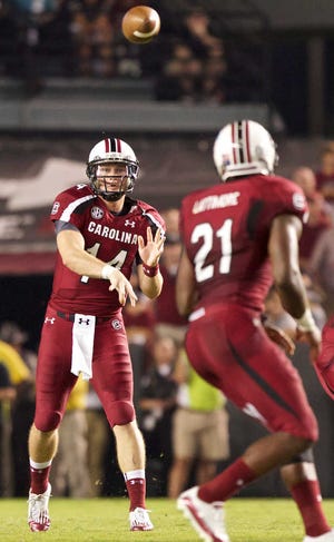 South Carolina quarterback Connor Shaw, left, throws a short pass to running back Marcus Lattimore for a first down in the first quarter against Georgia in their Southeastern Conference game Saturday night in Columbia, S.C. Shaw threw two touchdown passes and ran for a TD as No. 6 South Carolina beat No. 5 Georgia, 35-7.