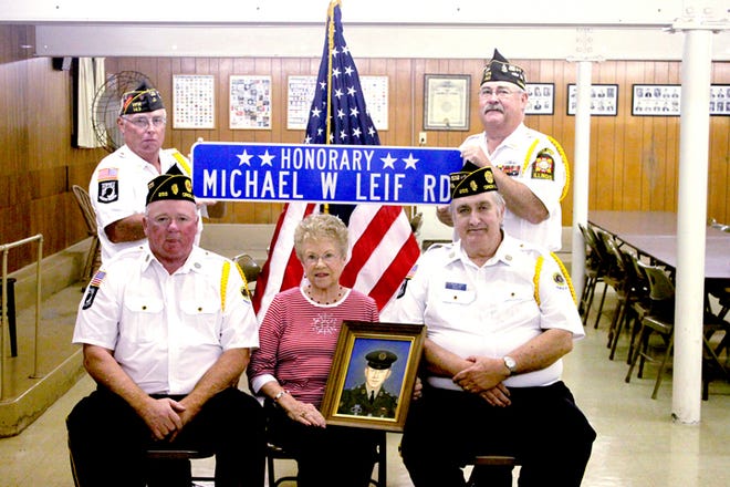 Michael Leif, the only Orion school district resident who died in the Vietnam War, will be remembered with a ceremony at his gravesite in Western Township Cemetery at 11 a.m. Saturday, Oct. 6, and a luncheon at Swedona Lutheran Church at noon. Leif's mother, Lois Leif, holds his portrait. Surrounding her are Vietnam veterans Bill Montgomery, seated at left; George Rose, seated at right; Darrel Muhleman, standing at left; and Ben Woolley, standing at right. A three-mile stretch of County Highway 7 has been named for Leif.
