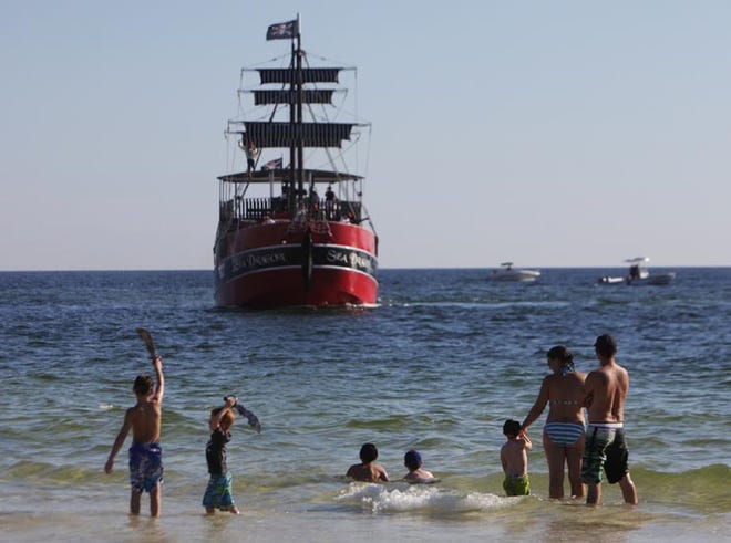 Children pretend to swordfight in the surf during a pirate invasion at the annual Pirates of the High Seas Festival in Panama City Beach Saturday.