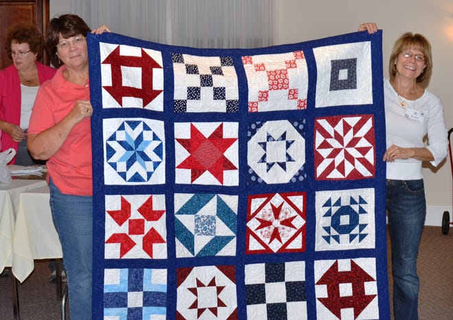 Guild members Mary Hamilton of Foxboro and Dora Dorral of Mansfield hold up a quilt to be raffled off on Oct. 6 at the club's quilt show to be held at Willow Crossing in Mansfield from 10a.m.-3p.m.