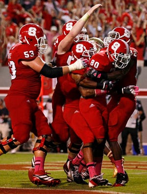 N.C. State's Bryan Underwood, 80, is mobbed by teammates after scoring the game-winning touchdown against Florida State on Saturday.