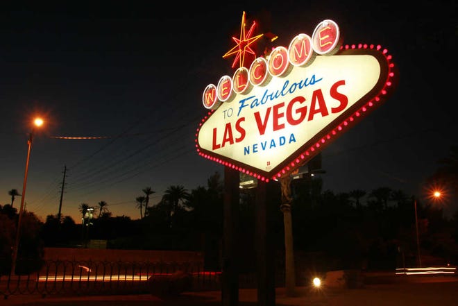 The "Welcome to Las Vegas" sign is outlined in pink lightbulbs in honor of breast cancer awareness Thursday, Oct. 4, 2012. (AP Photo/Las Vegas Sun, Sam Morris)