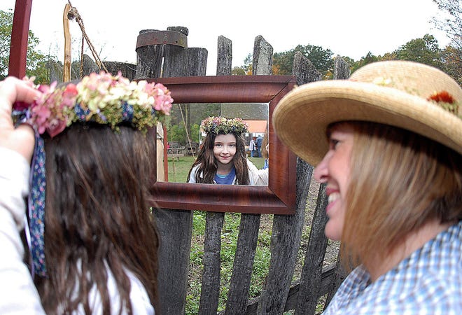 Natalie Scott tries on her “Everlasting Children's Halo” with the help of creator Kathleen Mosier during the annual Harvest Festival.
