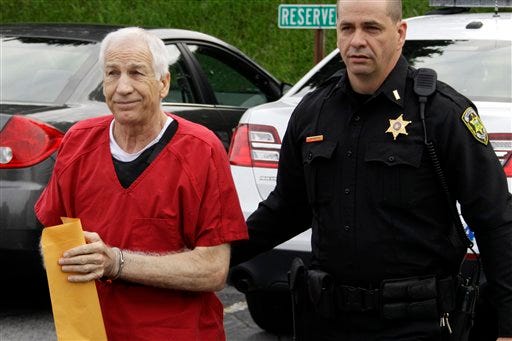 Former Penn State University assistant football coach Jerry Sandusky, left, arrives for sentencing on child sex abuse charges at the Centre County Courthouse in Bellefonte, Pa., Tuesday, Oct. 9, 2012.