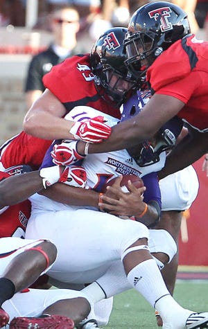 Northwestern State's Brad Henderson is taken down by Texas Tech's Kerry Hyder, Jackson Richards and Delvon Simmons during their game on Saturday in Lubbock. (Zach Long)