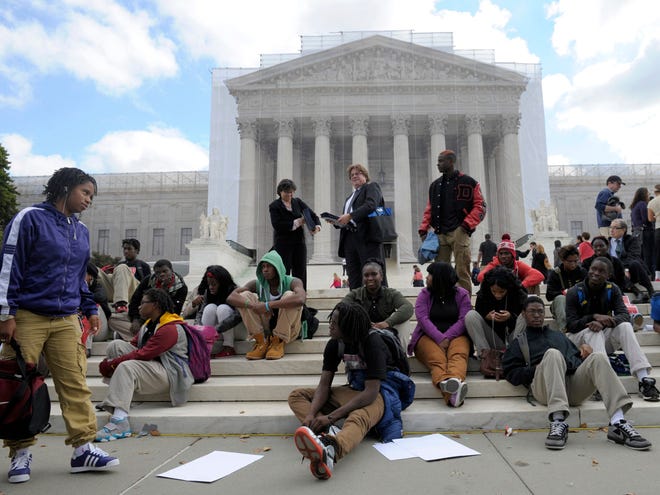 People supporting the University of Texas rally outside the Supreme Court in Washington on Wednesday. The Supreme Court is taking up a challenge to a University of Texas program that considers race in some college admissions. (AP Photo/Susan Walsh)