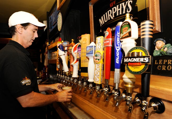 SAGAMORE -- John Downes, owner of Flynn's Irish Pub, pours a pint from one of his 32 taps. The pub has been open for 8 months and also offers a full dinner menu with complimentary, serve yourself soup for any patron who orders an entree.