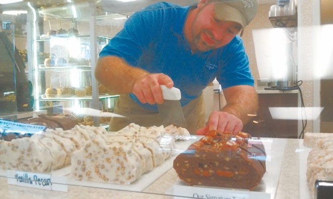 R. Jay Morgan, store supervisor for Kilwins' Mackinaw City location at 226 E. Central Ave., places fresh vanilla fudge in a display case for Wednesday's sales. The candy maker has received the go-ahead from the Food and Drug Administration after a recall involving a sugar-free peanut butter product. The candy at issue was not sold in Mackinaw City, a company spokesperson said.