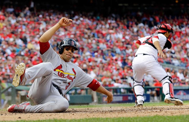 St. Louis Cardinals' Carlos Beltran, left, slides into home plate past Washington Nationals catcher Kurt Suzuki for a run on a single by Matt Holliday in the eighth inning of Game 3 of the National League division baseball series on Wednesday, Oct. 10, 2012, in Washington. (AP Photo/Alex Brandon)