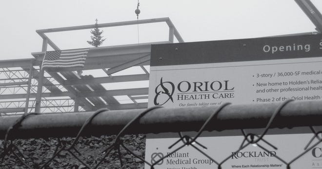 Rainy skies couldn’t dampen the crowd’s enthusiasm as the final steel beam was dropped into place on the newest medical building on the Oriol Health Care campus. The evergreen tree, a traditional touch, symbolizes growth.
