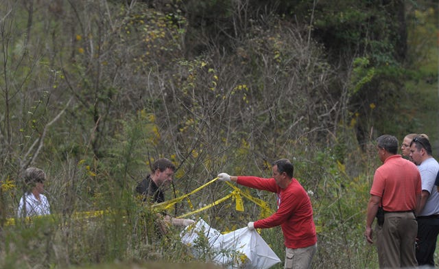 Investigators search the area after a body was discovered in some woods along Union Ridge Road Oct. 3. The remains were identified by police on Friday as belonging to Debra Sellars.