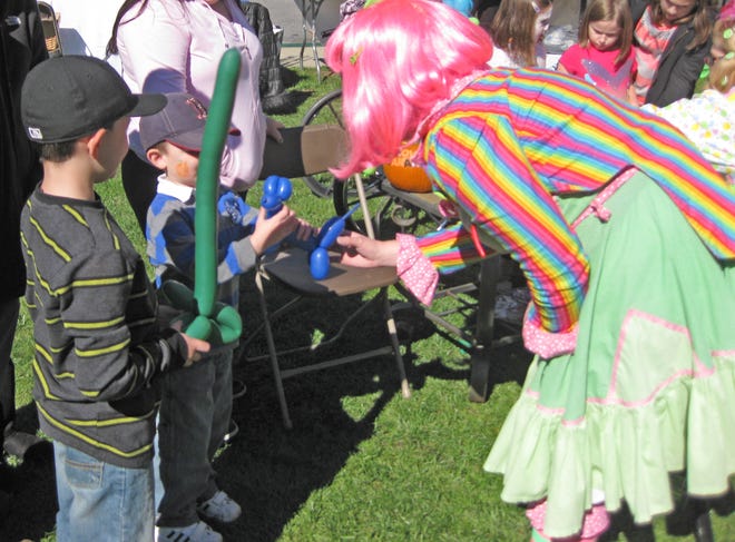 Lala the Clown gives a balloon animal to Ayden Freelove, 4, and his brother Zachary, 8, at the Life Care Center of Raynham's Fall Festival on Saturday.