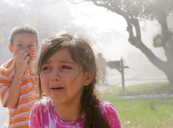 Corbin and Zoë Griesmyer react as smoke fills the air and firefighters fight the blaze in Millville.