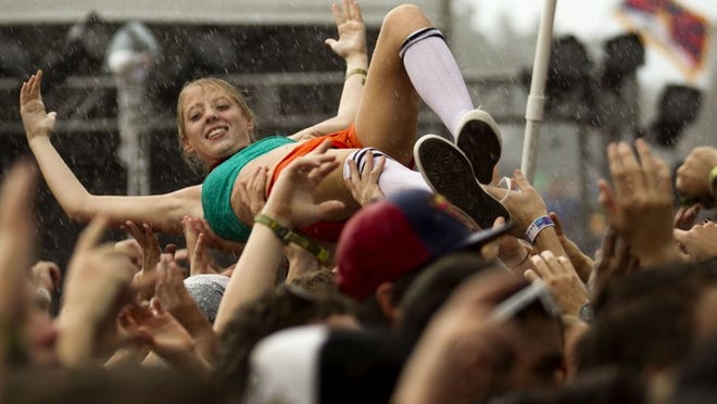 A woman crowd surfs during a heavy downpour during the performance by Big Gigantic.