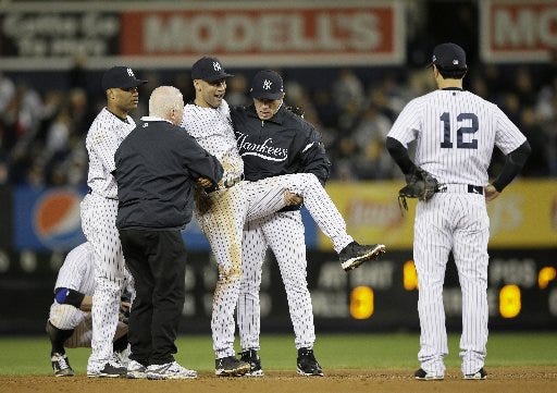 Trainer Steve Donohue (second from left) and New York Yankees manager Joe Girardi (second from right) help Derek Jeter off the field after he injured himself during Game 1 of the American League championship series against the Detroit Tigers Sunday in New York. New York Yankees' Robinson Cano (left) and Eric Chavez stood by.