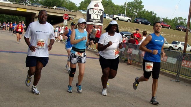 Renaulda (left) and LaTara (second from right) members of the Back On My Feet running program take part in the Too Hot to Handle 5K in Dallas this summer with Laurie Dias (second from left) and Rick Wilson.