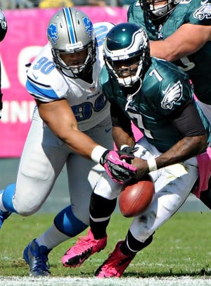 Eagles quarterback Michael Vick (7) has the ball knocked loose by Lions’ defensive tackle Ndamukong Suh (90) during the first quarter Sunday. Vick recovered his own fumble.
