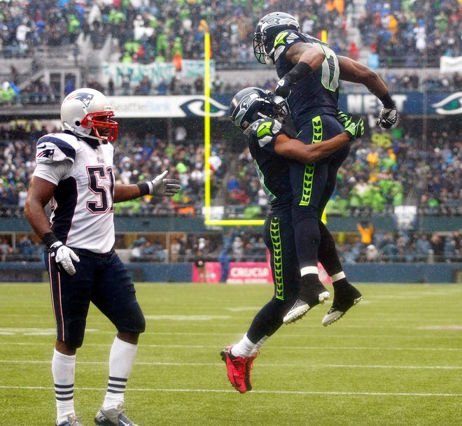 Seattle Seahawks' Braylon Edwards, right, celebrates with Seahawks' Golden Tate as New England Patriots' Jerod Mayo looks on at left, after Edwards caught a pass for a touchdown in the second half of an NFL football game, Sunday, Oct. 14, 2012, in Seattle. (AP Photo/John Froschauer)