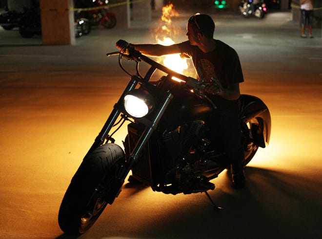 Travis Guidry shoots flames out of the tailpipe of his motorcycle at the kickoff party for Thunder Beach Week at the Shores of Panama in Panama City Beach.