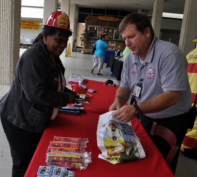 NAS Jax Fire Inspector Michael Minnie passes out free fire prevention material to Donna Bethea at the Navy Exchange Complex on Oct. 9 to promote Fire Prevention Week.